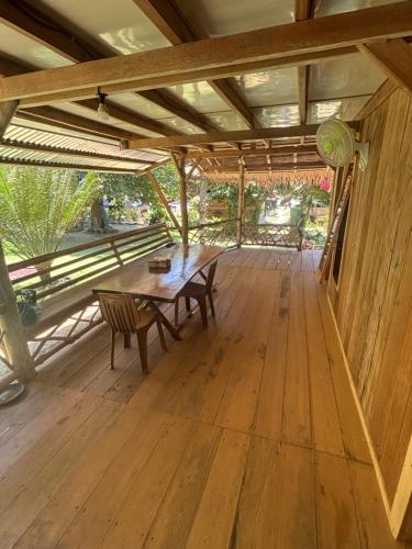a wooden deck with a table and bench on it at Moile Moile Surfcamp in Masokut