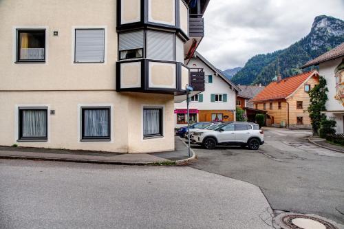 a car is parked next to a building at Alpina Apartment in Oberammergau