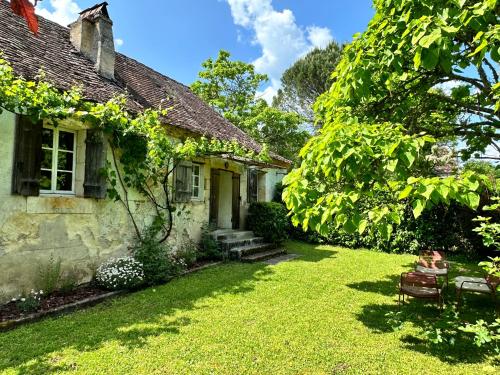 an old stone house with a grass yard at the Snug House in Maurens