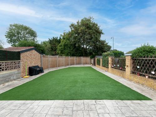 a artificial lawn in a backyard with a fence at 4 Bed house Parking 5 mins Sidcup Station - Pass the Keys in Sidcup