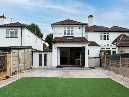 a white house with a lawn in front of it at 4 Bed house Parking 5 mins Sidcup Station - Pass the Keys in Sidcup