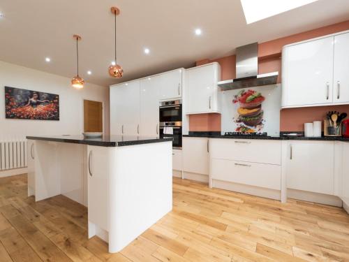 a kitchen with white cabinets and a black counter top at 4 Bed house Parking 5 mins Sidcup Station - Pass the Keys in Sidcup