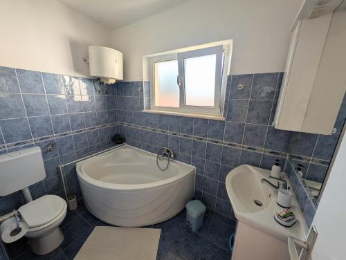 a bathroom with a tub and a toilet and a sink at Apartments Ante in Lumbarda