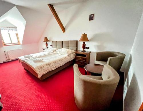 una camera da letto con un letto, una scrivania e delle sedie di Hotel Fogl a Nová Bystřice