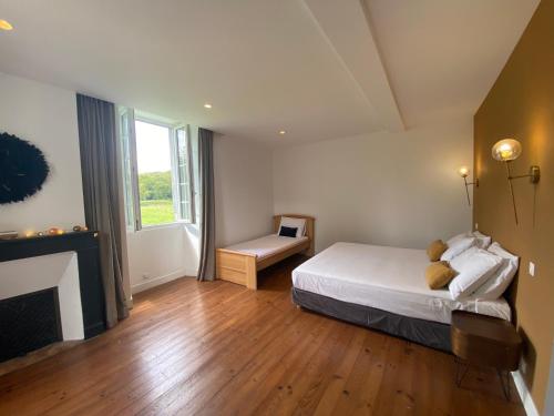 - une chambre avec un lit, une cheminée et une fenêtre dans l'établissement Maison Paisible au coeur des Pyrénées, à Igon