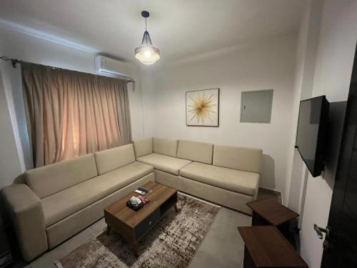 un salon avec un canapé et une table dans l'établissement Celia, à Madīnat al Amal