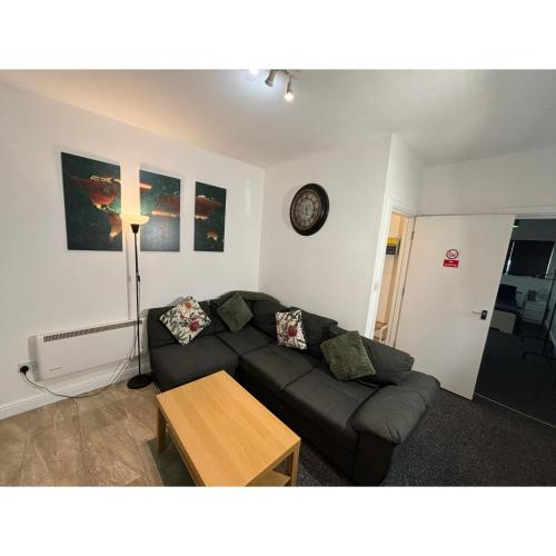 a living room with a couch and a table at Orchard Court Spacious one bedroom apartment with extra sofa bed in Wednesbury