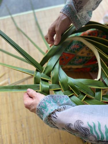 a person with tattoos on their hands holding a plant at The Tiing Tejakula Villas in Tejakula
