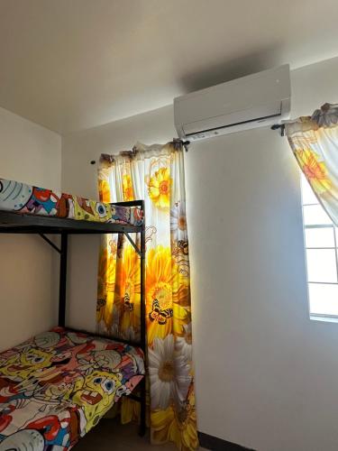 ein Schlafzimmer mit Etagenbett und Fenster in der Unterkunft 2 StoryHome in Tanza near SM along Main Road in Tanza