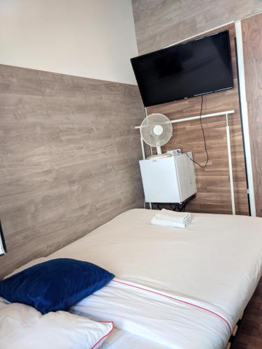 a bedroom with a bed with a tv on the wall at PARAISO Da PENHA in Lisbon