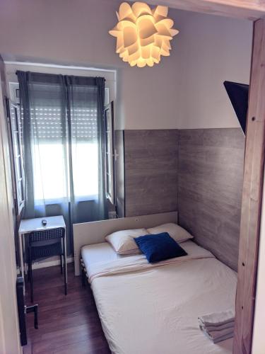 a small bedroom with a bed and a chandelier at PARAISO Da PENHA in Lisbon