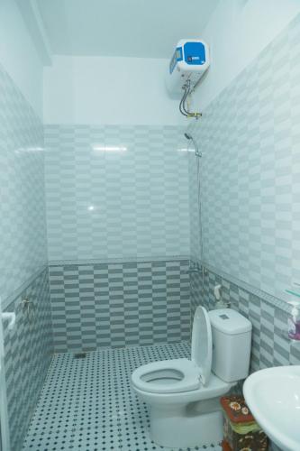 a white bathroom with a toilet and a sink at Gold Plus hotel in Phong Nha