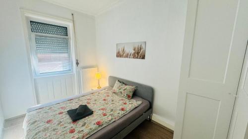 une petite chambre avec un lit et une fenêtre dans l'établissement Gemütliche Altbauwohnung in Stuttgart Ostendplatz, à Stuttgart