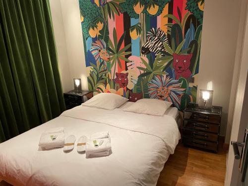 une chambre avec un grand lit blanc avec des serviettes dessus dans l'établissement Appartement familial au coeur de Paris, à Paris