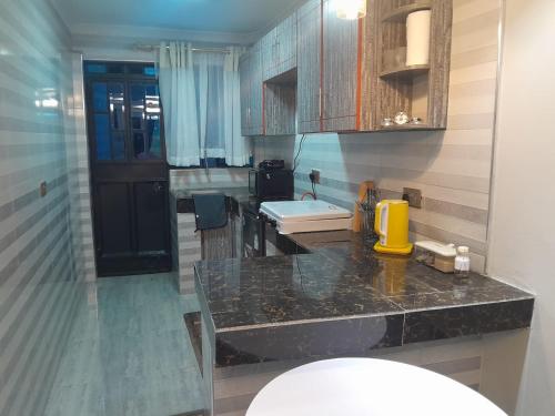 a kitchen with a black counter top and a sink at Weber Generations Accommodation -R & R Cozy Homes in Naivasha