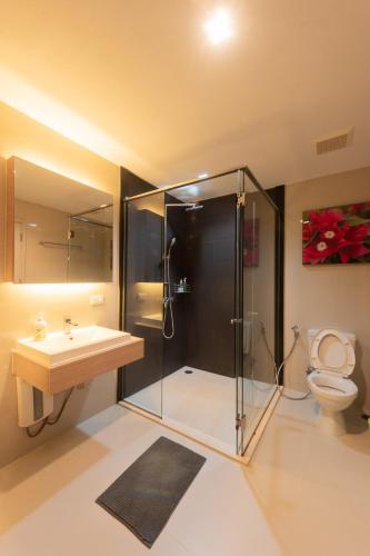 a bathroom with a shower and a sink and a toilet at Panoramic Pool at The Valley in Pak Chong