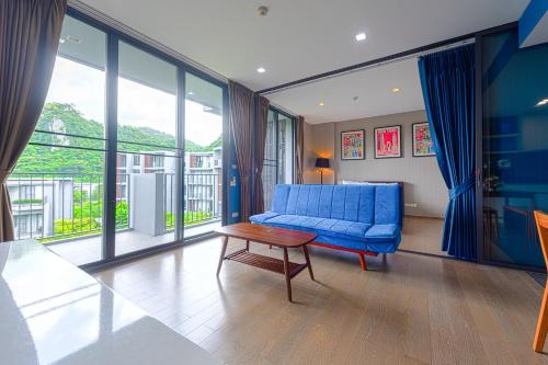 a living room with a blue couch and a table at Panoramic Pool at The Valley in Pak Chong