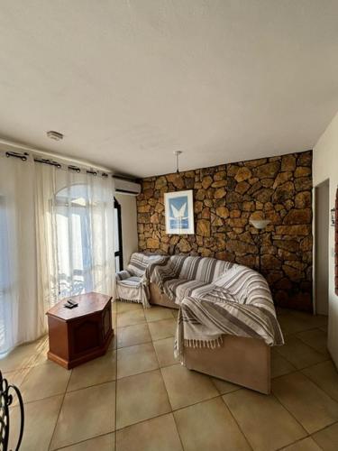 a bedroom with two beds and a stone wall at Cozy beachside in Xlendi