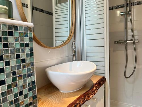 une salle de bain avec un lavabo blanc et une douche dans l'établissement Charmant studio parisien au cœur du 15e arrondissement, à Paris