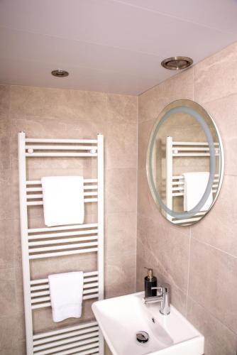 a bathroom with a sink and a mirror at Braeside Guest House, Loch Lomond in Drymen