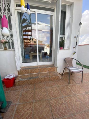 a patio with a chair and a glass window at The hidden Place in Alcaudete
