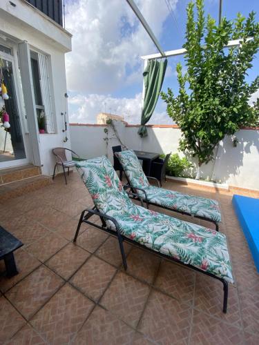 a patio with two chairs and an umbrella at The hidden Place in Alcaudete