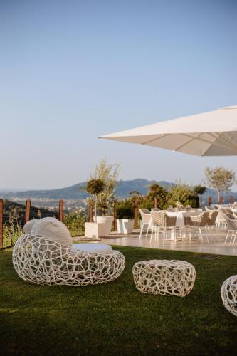 a group of chairs and tables on the grass at Boutique Hotel Municipio 1815 in Valdobbiadene