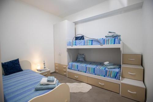 a bedroom with a bed and bunk beds at Senza Pensieri Holiday Home in Balestrate