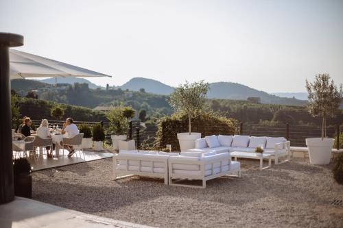 a group of white couches and tables on a patio at Boutique Hotel Municipio 1815 in Valdobbiadene