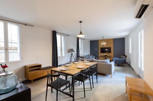 une salle à manger et un salon avec une table et des chaises dans l'établissement La clé des remparts - 3 chambres - Wifi - Intramuros, à Avignon