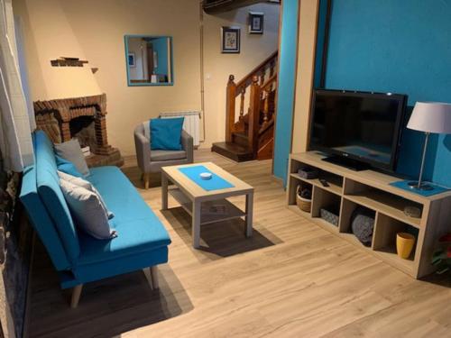 a living room with a blue couch and a television at La Casuca de Coo in Coó
