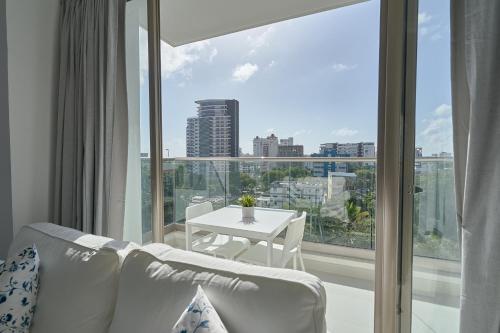 a living room with a white couch and a table at Apartments in La Julia 1 and 2 Bedrooms in Santo Domingo