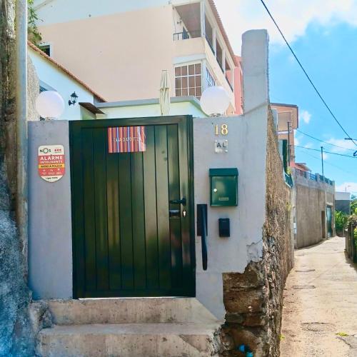 a green door on the side of a building at Casa D'Avó Filó in Funchal