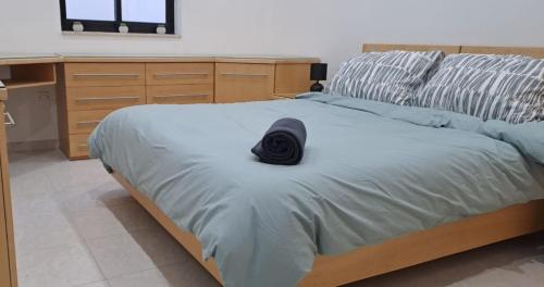 a black hat sitting on a bed in a bedroom at Spacious Getaway in Attard with Terrace & Garage in Attard