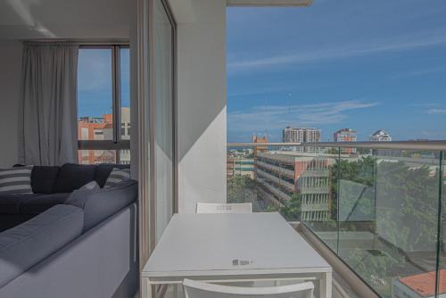 a living room with a couch and a large window at Apartments in La Julia 1 and 2 Bedrooms in Santo Domingo