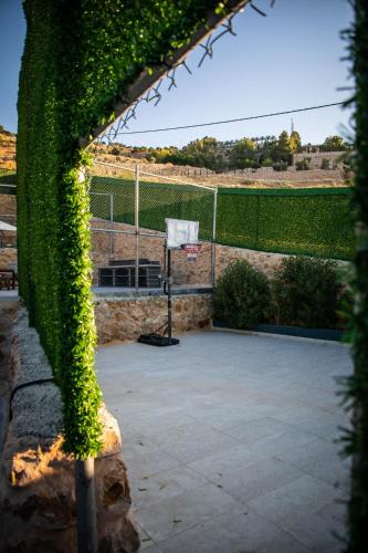 an ivy covered fence with a basketball court at Makanak Villas in Jerash