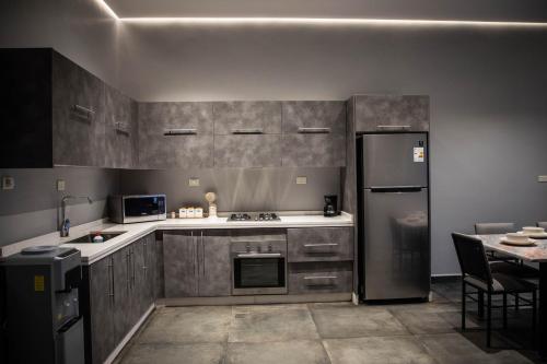 a kitchen with stainless steel appliances and a table at Makanak Villas in Jerash