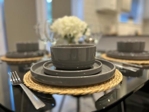 a black coffee cup and plates on a table at Comfortable 3 bed house in central location, Stevenage in Stevenage