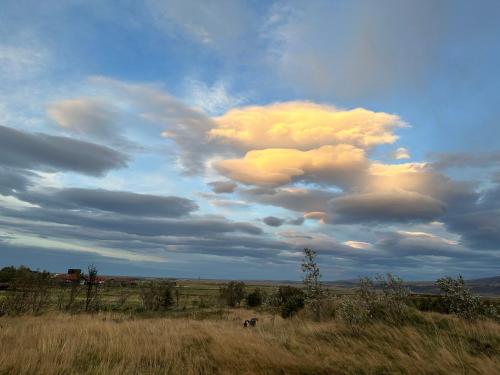 a cloud formation in the sky over a field at Broddaborg Apartments in Ölfus
