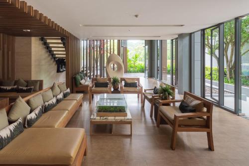 a lobby with couches and tables and windows at The Valley at Sunshine, Panoramic in Pak Chong