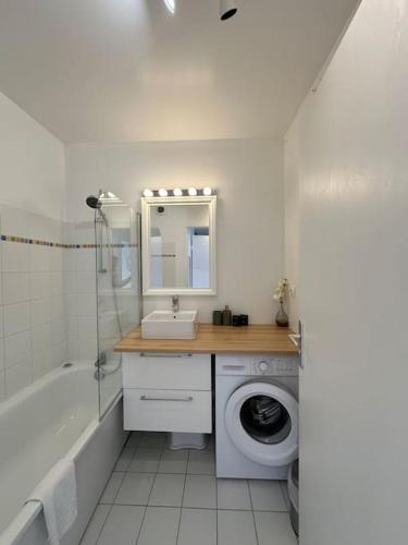 une salle de bain avec un lavabo et une machine à laver dans l'établissement Place Toscane Appartement Long séjour, à Marne-la-Vallée