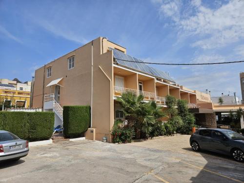 a building with a car parked in a parking lot at Eco Avenida Hotel & Parking in Benicàssim