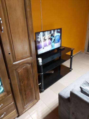 a living room with a flat screen tv on a table at Diaspo Meublés in Yaoundé