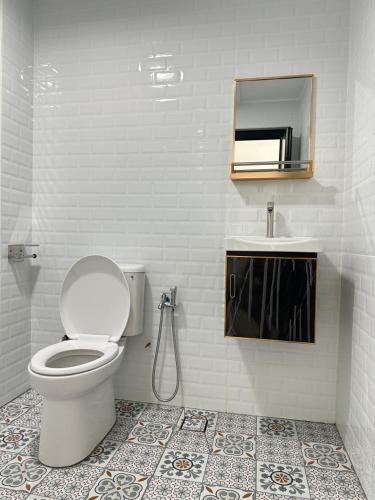 une salle de bain avec toilettes, lavabo et miroir dans l'établissement Deluxe room marina View Villas, à Port Dickson