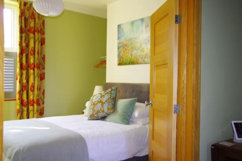 a bedroom with a bed with white sheets and a window at Stylish Garden Apartment, Exmouth - 'Little Monty' in Exmouth