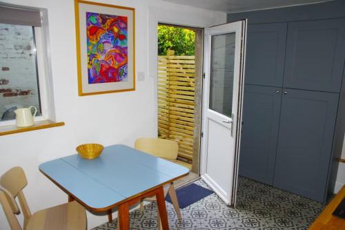 a dining room with a blue table and chairs at Stylish Garden Apartment, Exmouth - 'Little Monty' in Exmouth