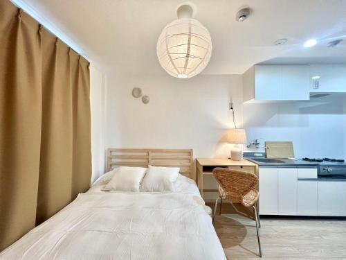 a bedroom with a bed and a desk and a kitchen at Shinjuku YC Hostel-SJ0399 in Tokyo