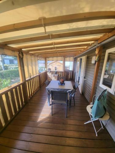 une terrasse couverte d'une maison avec une table et des chaises dans l'établissement Mobil-Home Montmartin-sur-mer, à Hauteville-sur-Mer