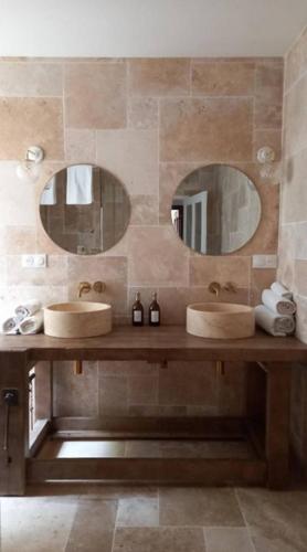 une salle de bain avec deux lavabos et deux miroirs dans l'établissement Maison Lama, à Lama
