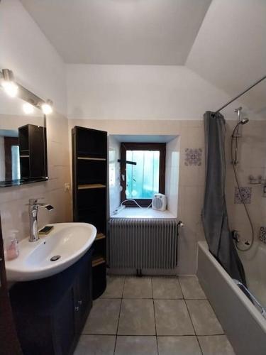 une salle de bain avec un lavabo, une baignoire et une douche dans l'établissement maison en pierres, à Pradinas